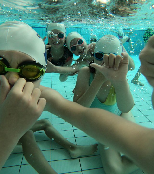 Dzieci pływające pod wodą podczas półkolonii pływackich